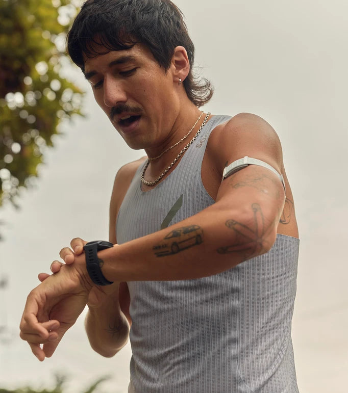 Running man talking on his watch outdoors with a blurred natural background.