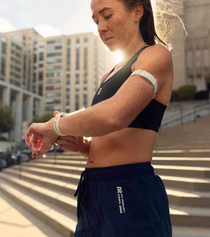 Female runner using media controls on her running watch PACE 4 from COROS